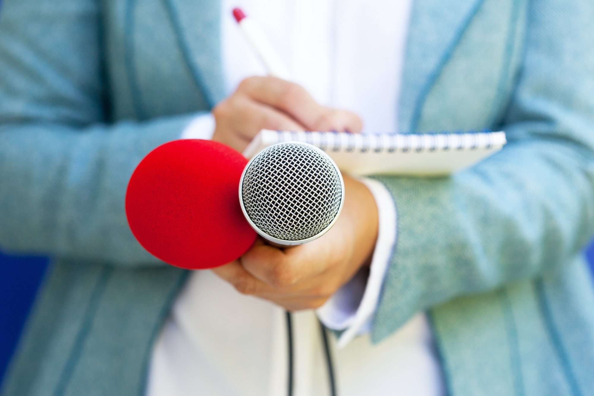 reporter taking notes with microphones and notepad