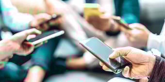 Many hands holding smartphones