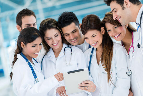 Group of doctors using health app on a tablet computer-min