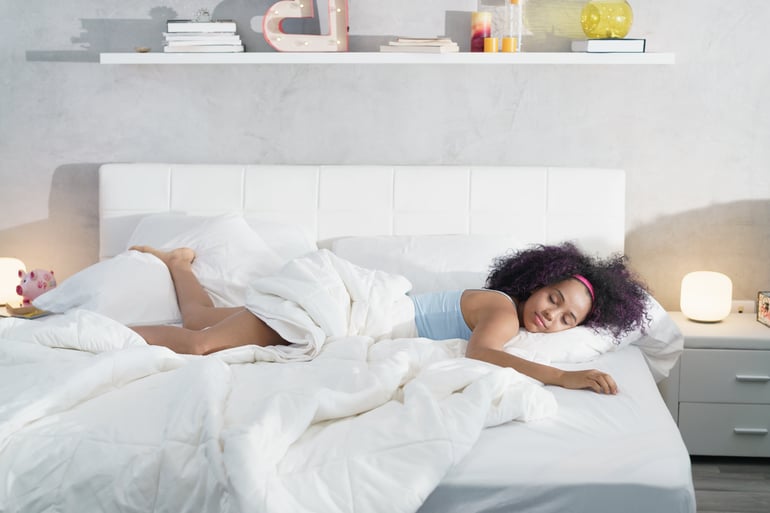 black-woman-sleeping-alone-in-large-bed-NF5HJ2E-min (1)