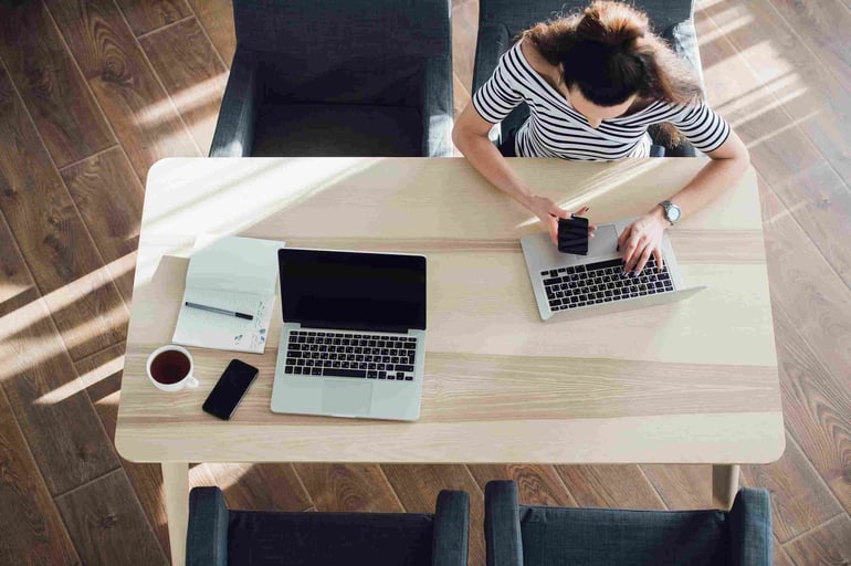 top-view-of-young-woman-sitting-at-desk-and-RM5KBN4-1-min