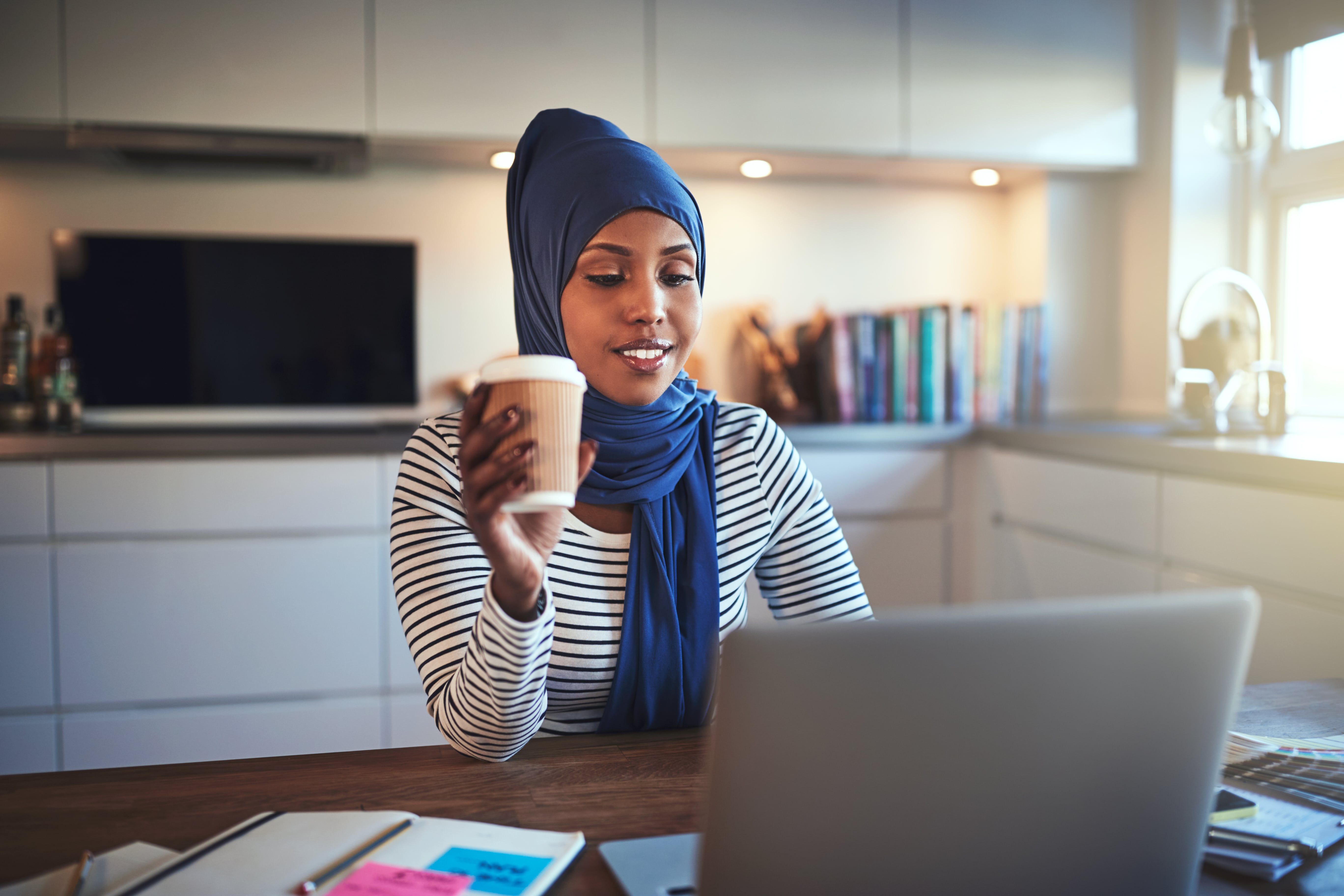 young-arabic-woman-drinking-coffee-and-working-JCBW54R-2-min