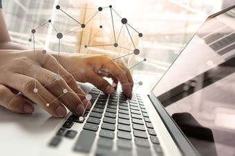 Hands typing on a laptop
