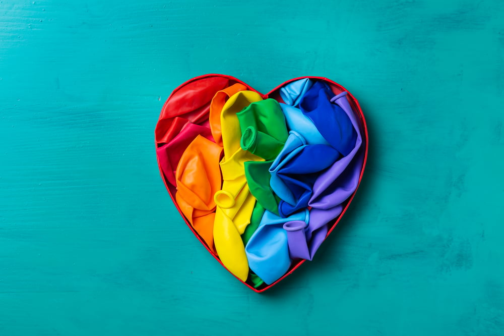 Rainbow-colored heart on teal background