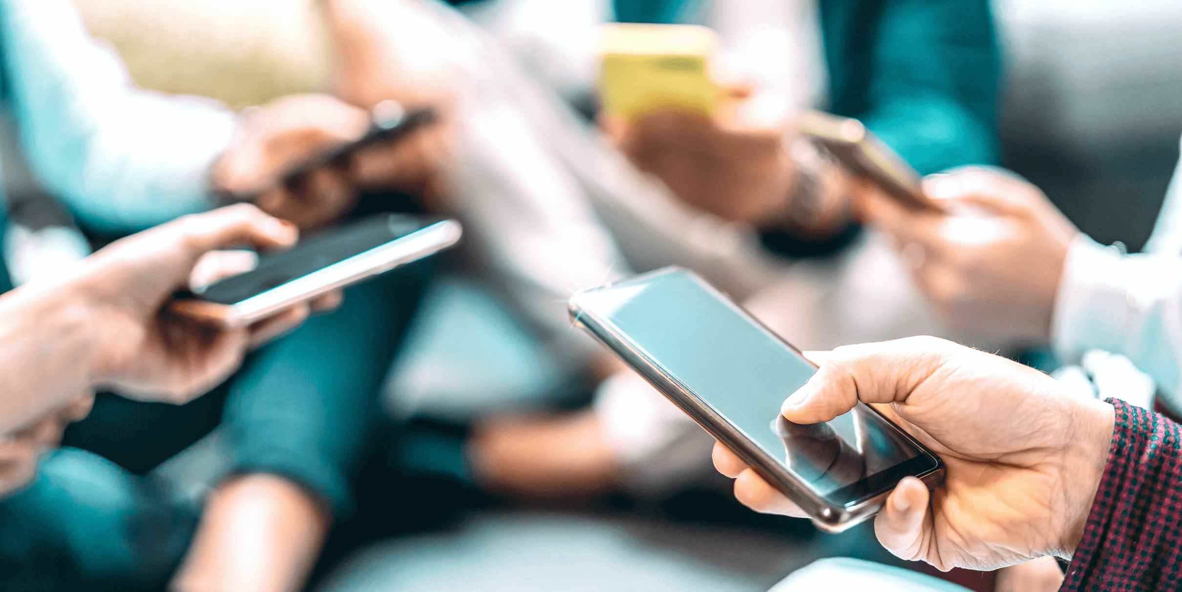 Many hands holding smartphones