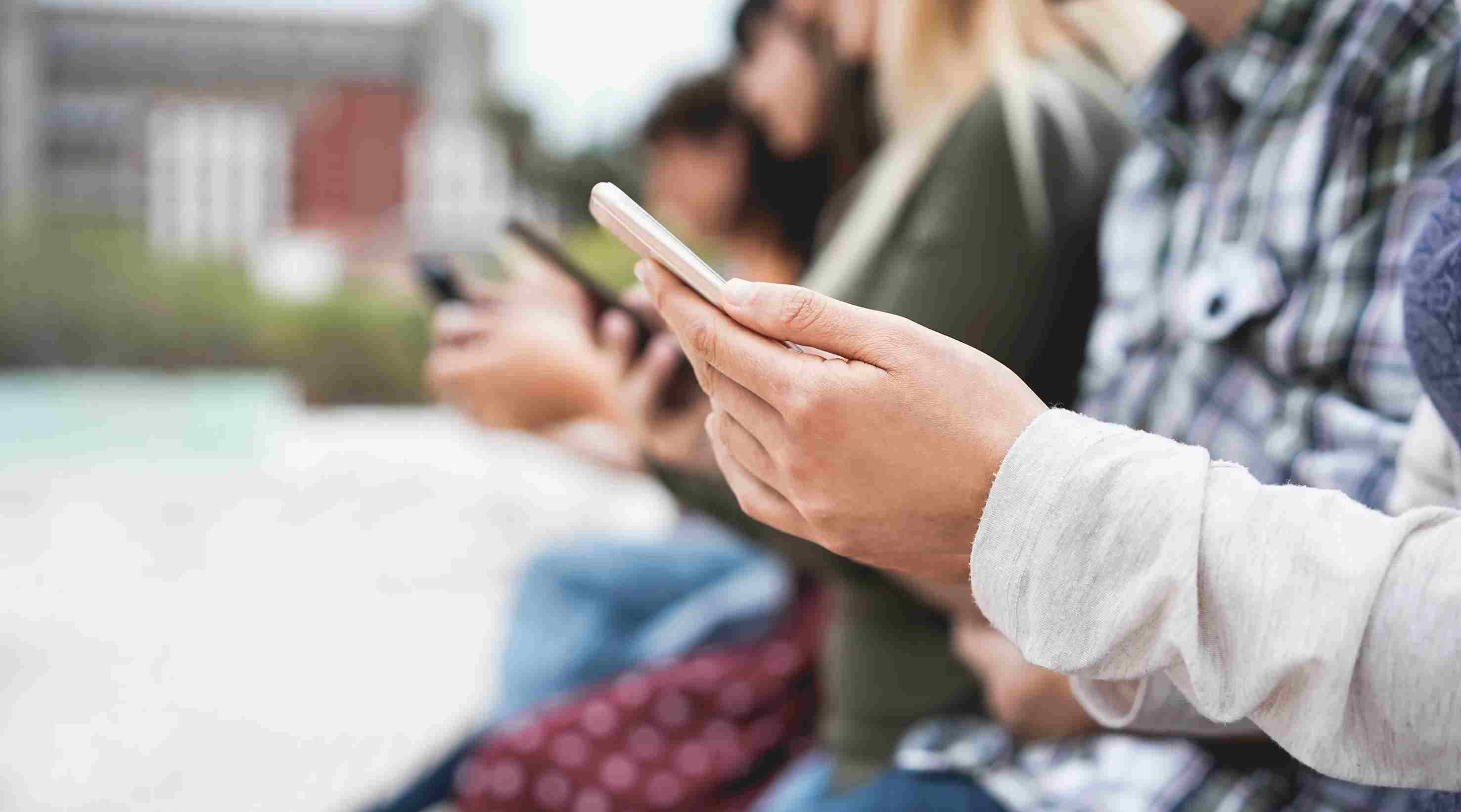 group-of-friends-watching-smart-mobile-phones-teen-42AYD7S